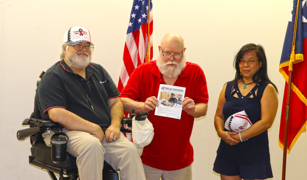 TCA Life Member Jim Hollingsworth (center) presents a copy of the latest Texas Knights to Chess Vets founders Michael Lenox (left) and Lia Lenox (right)—photo by Troy Gillispie.