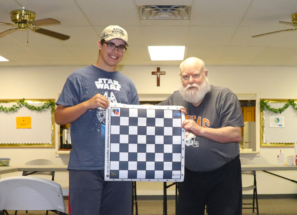 Jacob Wood (left), with Jim Hollingsworth (right), was awarded a commemorative chess board and set from TCA Affiliate Texas Armed Forces Chess (photo by Troy Gillispie).